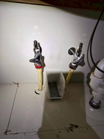 水栓を取り外す作業中の洗面台の下。管を外し、作業しやすい状態にした