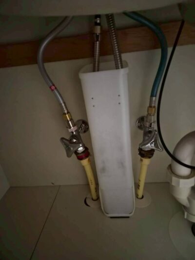交換後の洗面台の下。水とお湯の管をつないで工事は完了